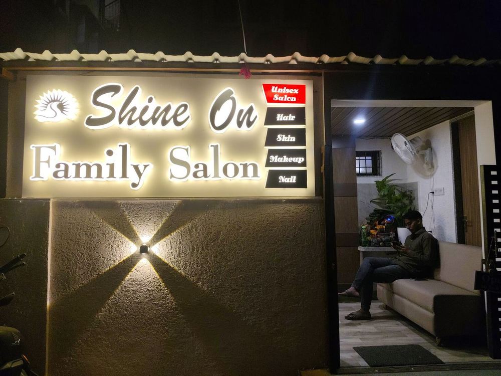 Lit Shine On Family Salon signboard at the entrance at night