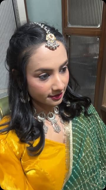 Festive look with yellow outfit, green dupatta and side-parted curls
